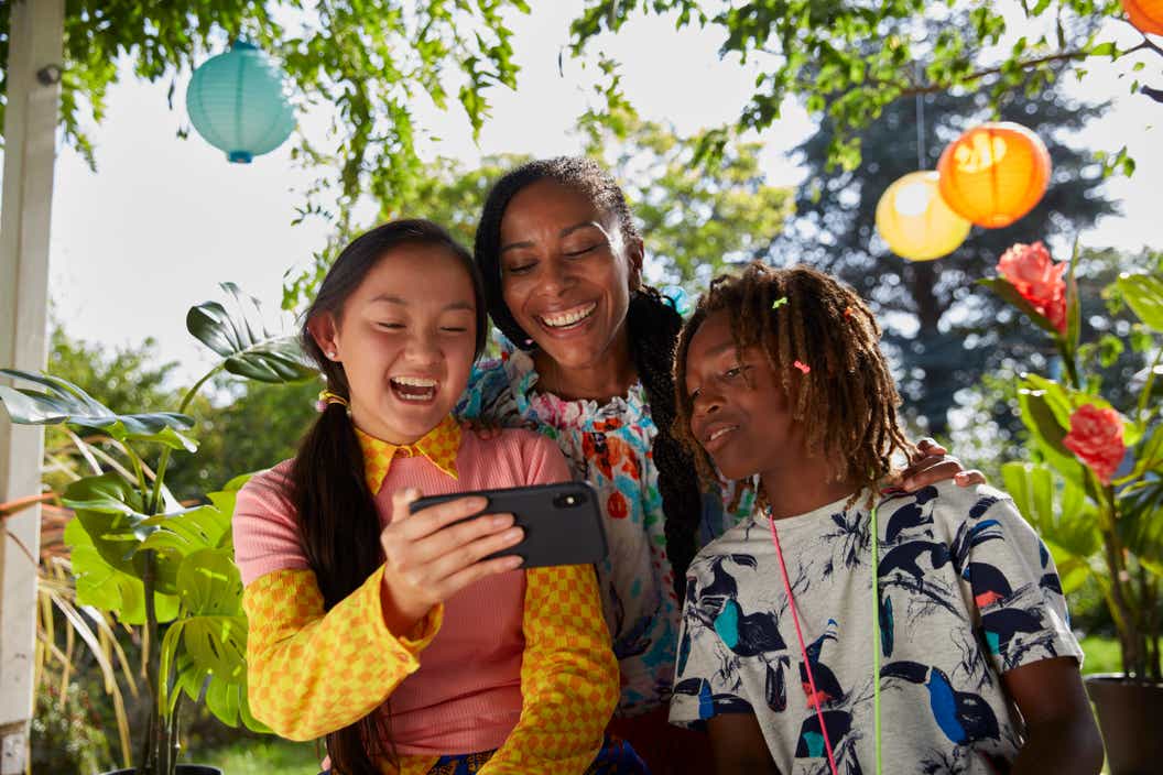 Lifestyle image of three children looking at the LEGO VIDIYO app on a cell phone