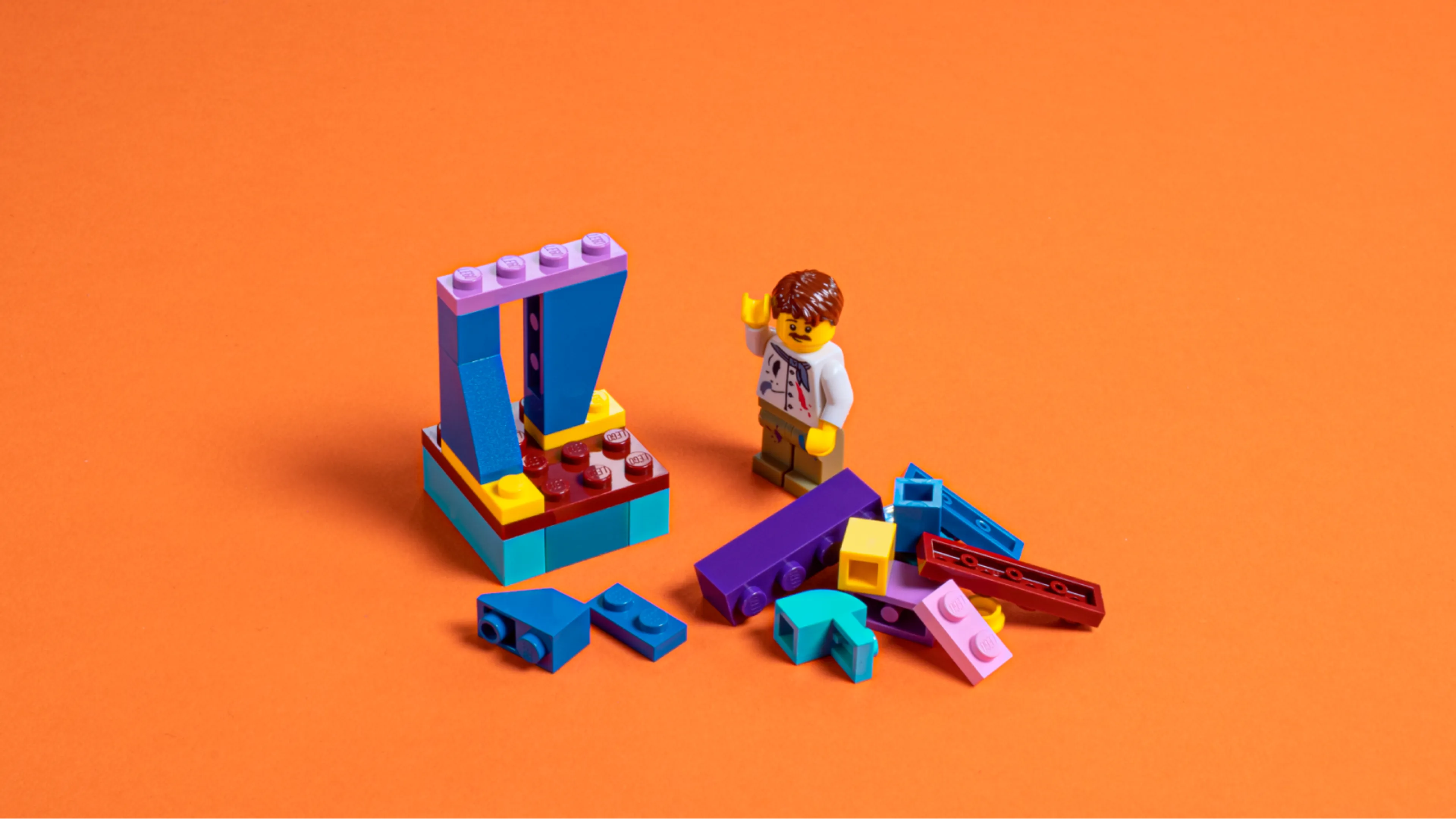 Eine Minifigur baut das Fundament der LEGO-Statue