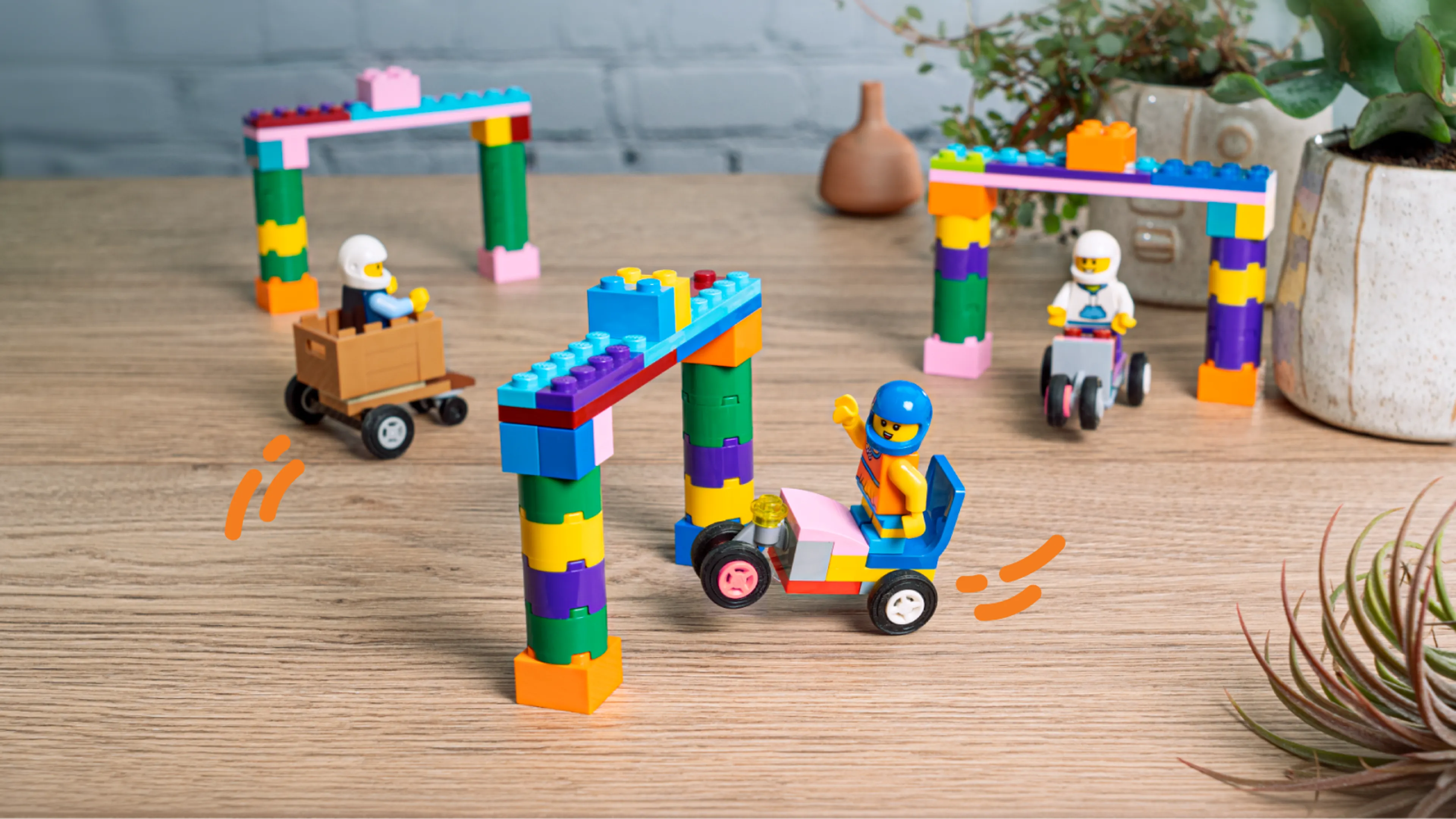 Minifigures racing through the track in LEGO soapbox cars