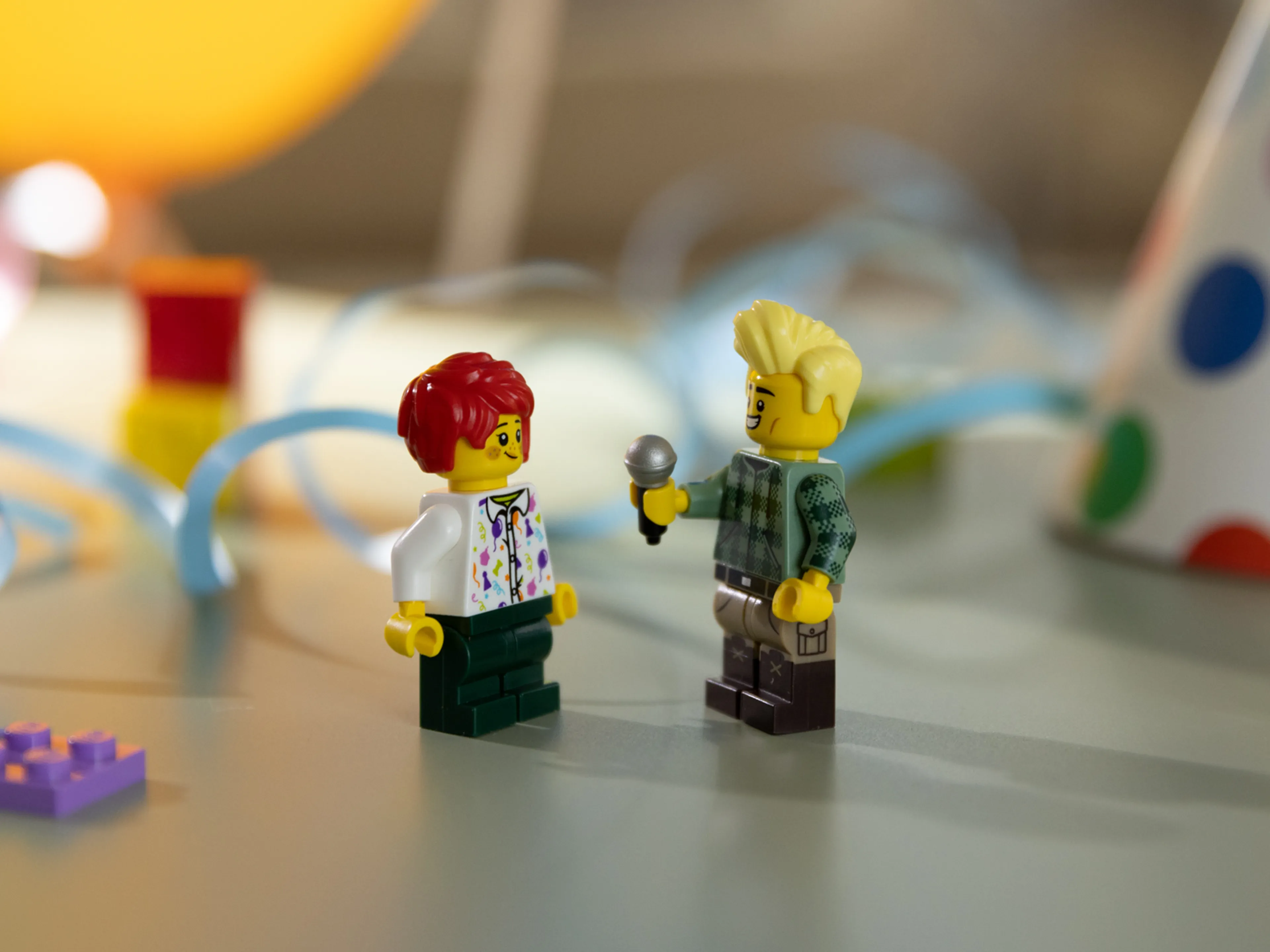 Two LEGO Mini-figures. One holding a LEGO microphone