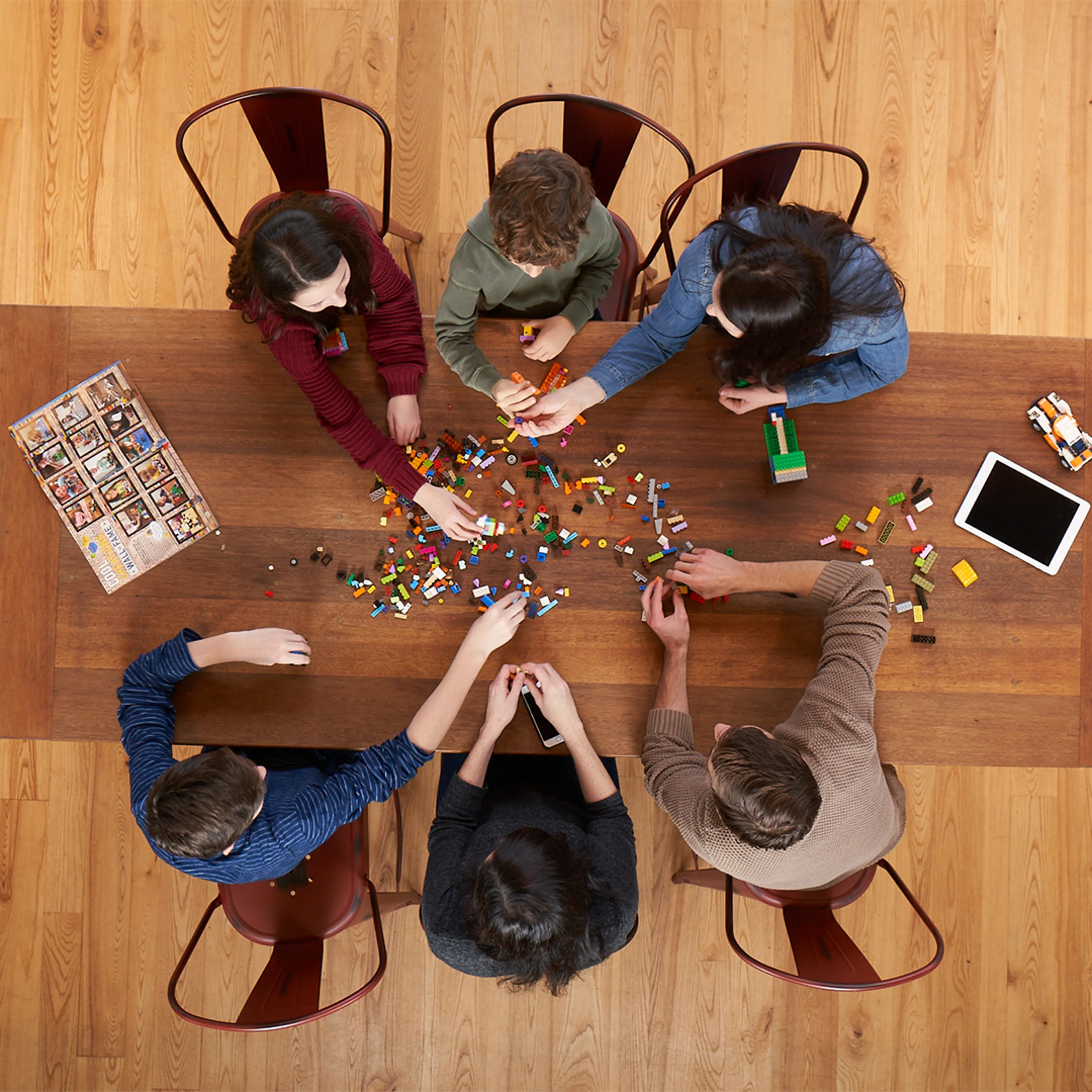 A top down view of a family playing with LEGO bricks