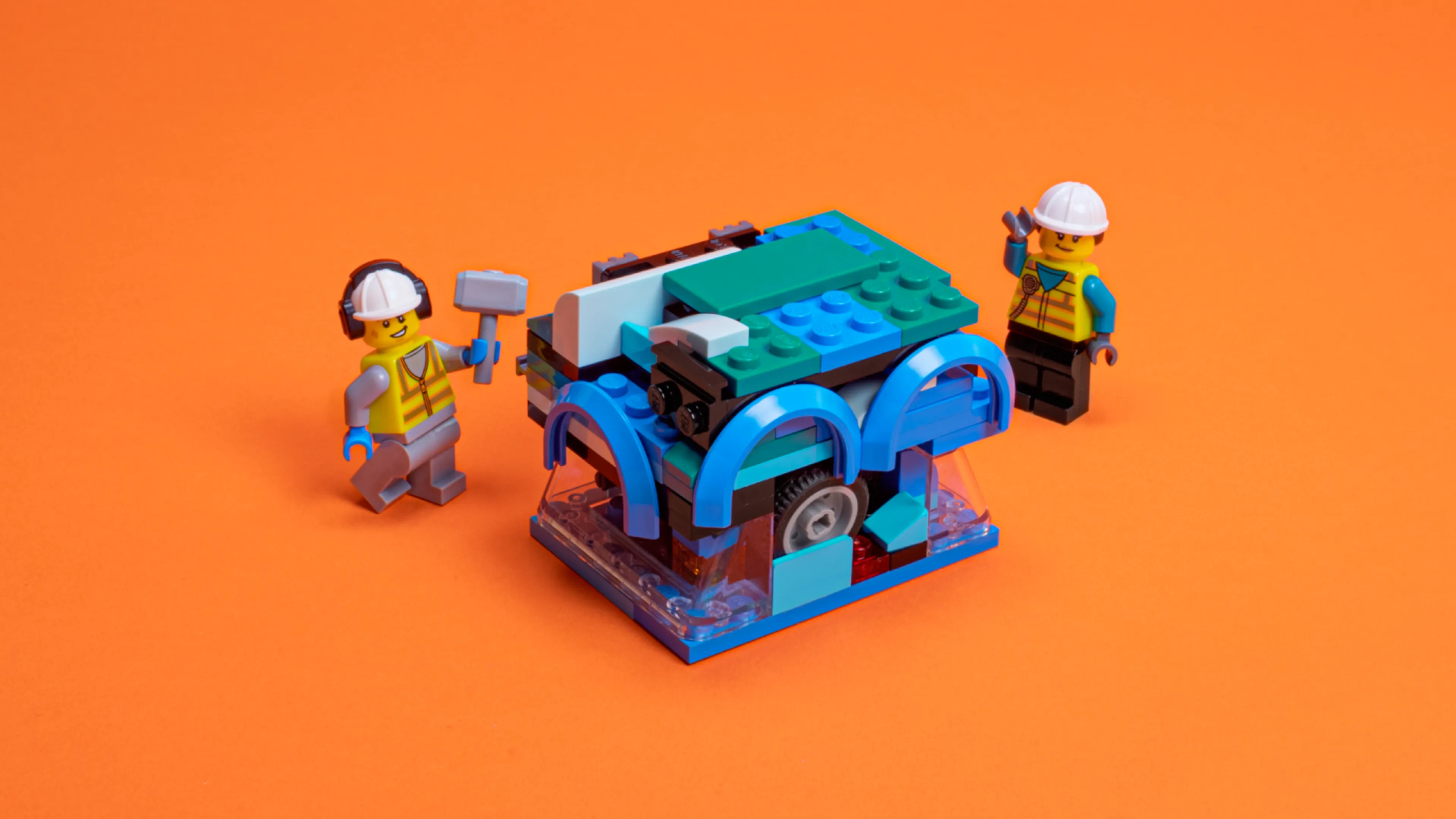 Two mechanic minifigures with a LEGO car turned into a cube